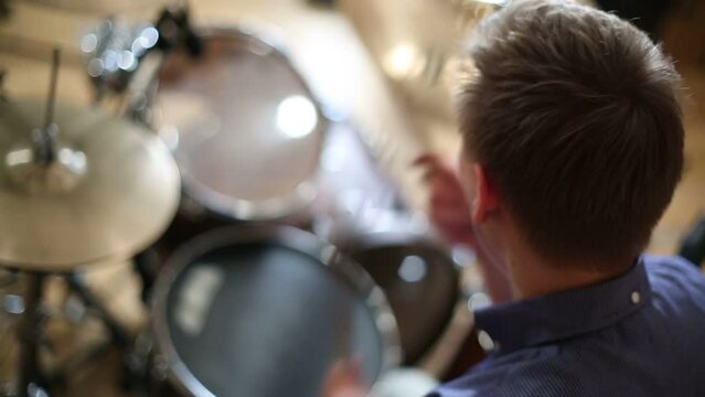 Head of young male drummer playing in modern recording studio 