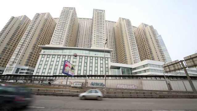 Moving by highway against multistoried residential apartments.