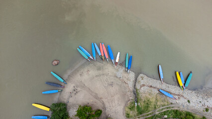 A few boats seen from the air on a river in a tropical rainforest