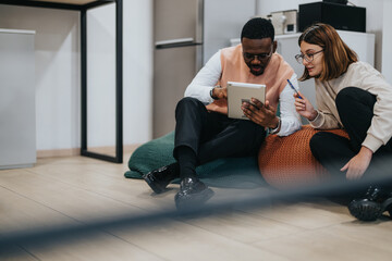 Diverse people collaborate late at night, analyzing reports and planning investments for business growth. They work together to meet project deadlines and solve problems in a creative workspace.