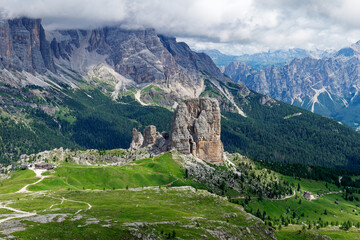Fototapeta na wymiar View of Cinque Torri with the Tofane mountain in the background covered with clouds. Famous climbing and alpinist place in the Dolomites, Italy. Travel destinations.