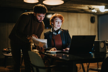 Confident young business people collaborating late at night in a creative office, discussing global market expansion and driving the success of their start-up group.