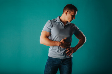 Appealing and well-built man standing in a green room and posing