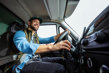 Young handsome man working in towing service and driving his truck.