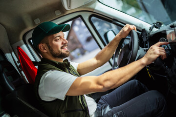 Young handsome man working in towing service and driving his truck.
