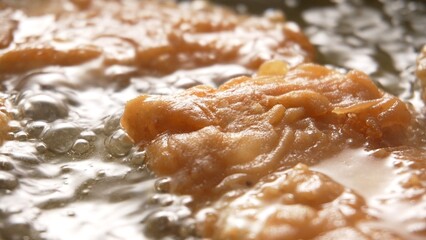 Crispy Fish Fillets Frying in Bubbling Oil. Close-up, Shallow dof.