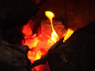 Yellow and orange flames over the embers of a winter bonfire