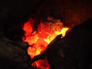 Yellow and orange flames over the embers of a winter bonfire