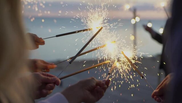 Bengal lights sparklers. Fireworks sparkling people hold in their hands. Evening in nature, summer day. Holiday festive celebration. New year, Christmas party.