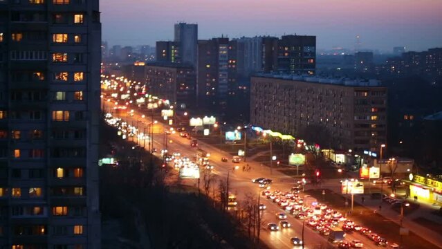 Busy car traffic in the evening at T-junction, top view.