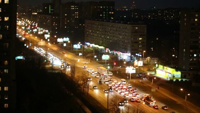Busy car traffic in the night at T-junction, top view.