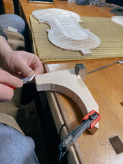 violin maker artisan cutting fillet purfling with tool to join other side of edge in inlaid channel