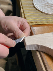 violin maker artisan cutting fillet purfling with tool to join other side of edge in inlaid channel