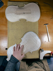 maker artisan perform purfling process on top plate of raw classical violin handmade overhead view