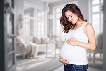 Happy pregnant woman standing at home, waiting for baby