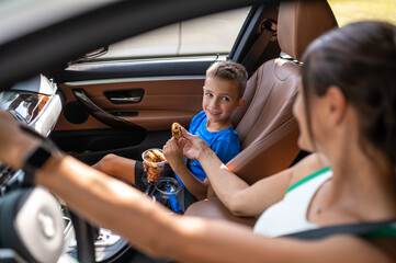 Mom and son sitting in the car and looking happy