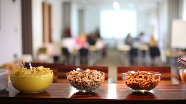 Many plates with different dry snacks on table in room