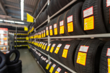 Blurred image rows of brand new tires for sale at retail store.