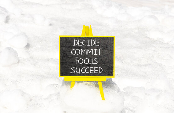 Decide commit focus succeed symbol. Concept word Decide Commit Focus Succeed on beautiful blackboard. Beautiful white snow background. Business decide commit focus succeed concept. Copy space.