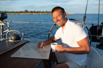 Good-looking positive man on a yacht feeling good