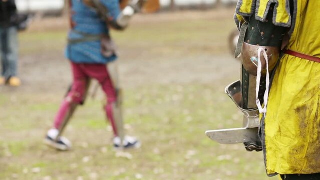 Hand of warrior in costume and fight of warriors out of focus