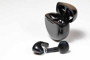 Black Wireless bluetooth earphone or earbud or headphone, isolated on white background.