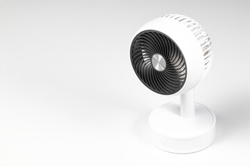 Small white plastic desktop fan side view, isolated on white background.