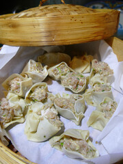 Steaming shumai dim sum in a bamboo steamer