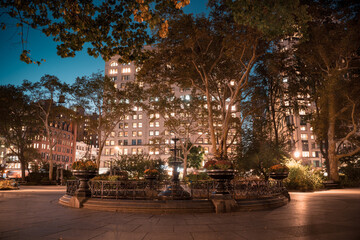 Madison Square Park in midtown Manhattan, New York City with fountain seen at night