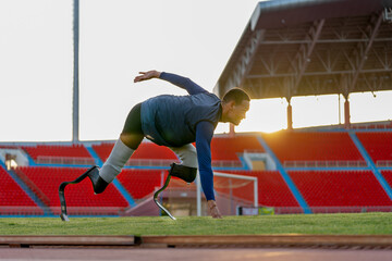 Sport man athlete prosthesis legs stay in the position of start running and look forward at the...