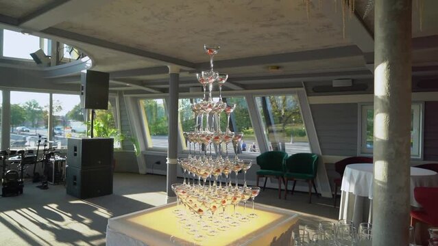 Tower of glasses at celebration party. Welcome drinks, tower of champagne or sparkling wine. Empty with red berry. Restaurant ready for reception. Alcoholic beverage.