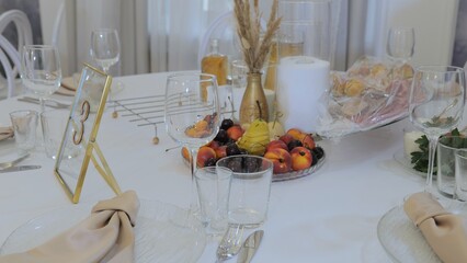 Elegant table setting in a luxurious restaurant. Luxurious banquet tables prepared for the official ceremony. A round table without food is served with plates, napkins, glasses and cutlery.