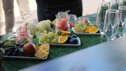 Buffet with fruits and drinks, champagne, juice. Fruit table for the holiday, Watermelon, orange and grapes. Catering with fresh fruit. Sweet natural food.