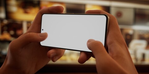 CU Photo of a person using his phone inside a fast-food restaurant, blank screen