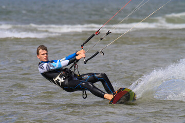 Obraz premium Junger, attraktiver KItesurfer in Aktion