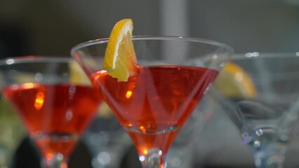 The waiter or bartender mixing cocktail in glasses. Welcome drink at a celebration or wedding reception in a restaurant or vacation bar. Alcoholic Beverage. Drinking straw.
