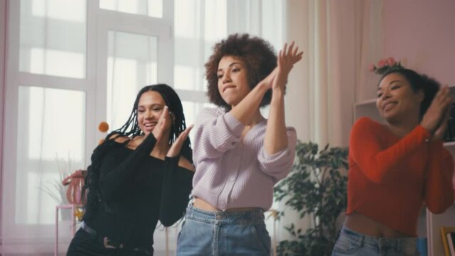Three young stylish African American women recording a dance for social media