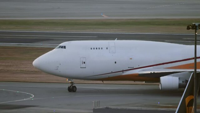 Cargo jumbo jet on the taxiway. Airfield of Hong Kong Airport. Widebody aircraft taxiing, side view