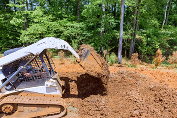 An using mini bulldozer capable of moving soil, working with earth improving territory