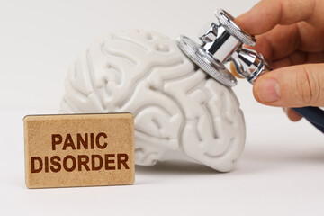 Using a stethoscope, the brain is diagnosed, next to it is a sign with the inscription - Panic disorder