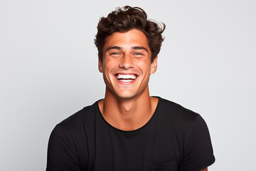 Smiling man with curly hair and black t-shirt, radiating joy and charisma. White Background - obrazy, fototapety, plakaty
