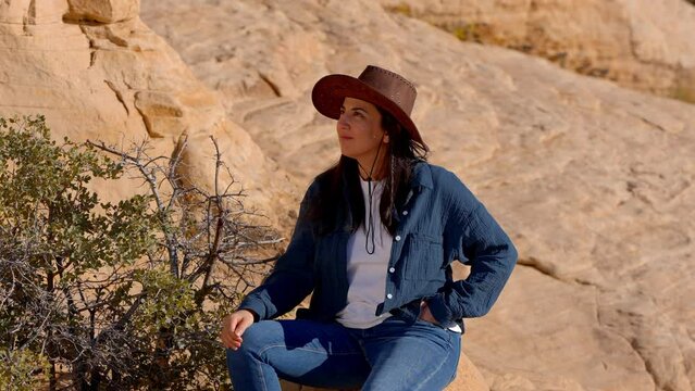 Cowgirl sitting on a rock in the desert of Nevada - travel photography