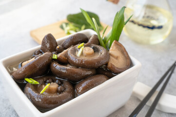 Appetizing marinated shiitake mushrooms in a salad bowl on a wooden table... marinated shiitake mushrooms, ready to eat.