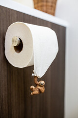 Cute sloth hanging on toilet paper