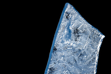 An ice shard fragment isolated on black background, macro photo
