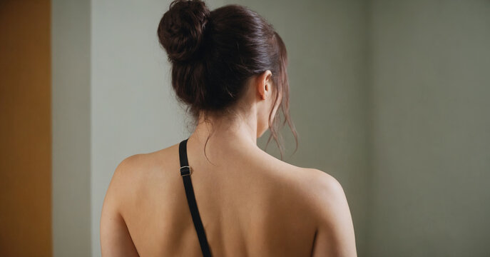 Aesthetic shot of a woman's back, highlighting a lingerie bra. Embracing the beauty of the female form, the image conveys fashion, health, and sensuality