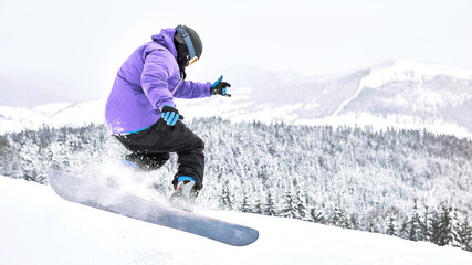 Shot of the freeride snowboarder that is making some trick while riding down from the hill. Extreme...