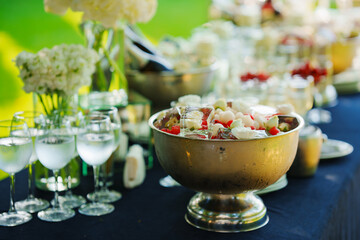 A bowl of ice cubes with frozen flowers and berries on the banquet table. 