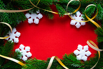 Winter red background with snowflake, gold tape and branch of Christmas tree.