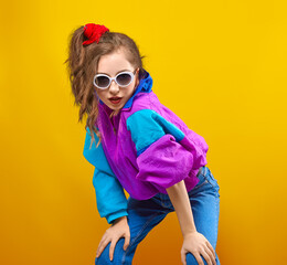 Fashion DJ girl in colorful trendy jacket from 90s. Cool Teenager shows strong face at the disco...